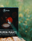 Solan Pakurin Mahti -saippua pahkan päällä niityn laidalla.