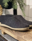 Glerupsin mustat nahkapohjaiset shoe-malliset huopatossut puisella alustalla.