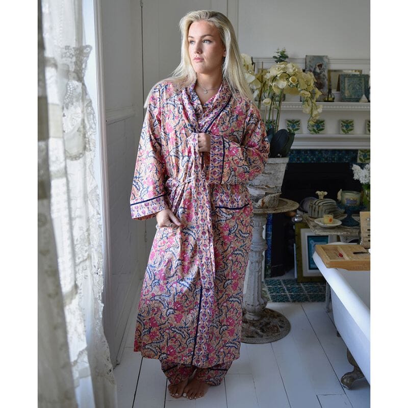 Powell Craftin Apricot, Navy & Persian Red Mixed Block Print -kuvioinen naisten kimono-aamutakki pitsiverhoisen ikkunan edessä poseeraavan naisen yllä.