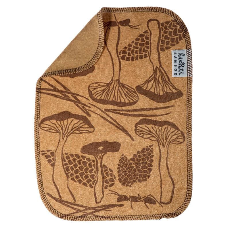 Kiertin Bambuinen tiskirätti - Sienimetsä sävyssä keltainen, jossa ruskeankeltaisella pohjalla ruskeita sieni- ja käpykuvioita. Kääntöpuoli yksivärinen ruskeankeltainen. 