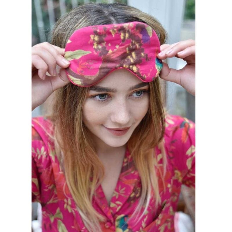 Powell Craftin Hot Pink Bird Print -unimaski ja samaa kangasta oleva pyjama vaaleahiuksisen nuoren naisen yllä.