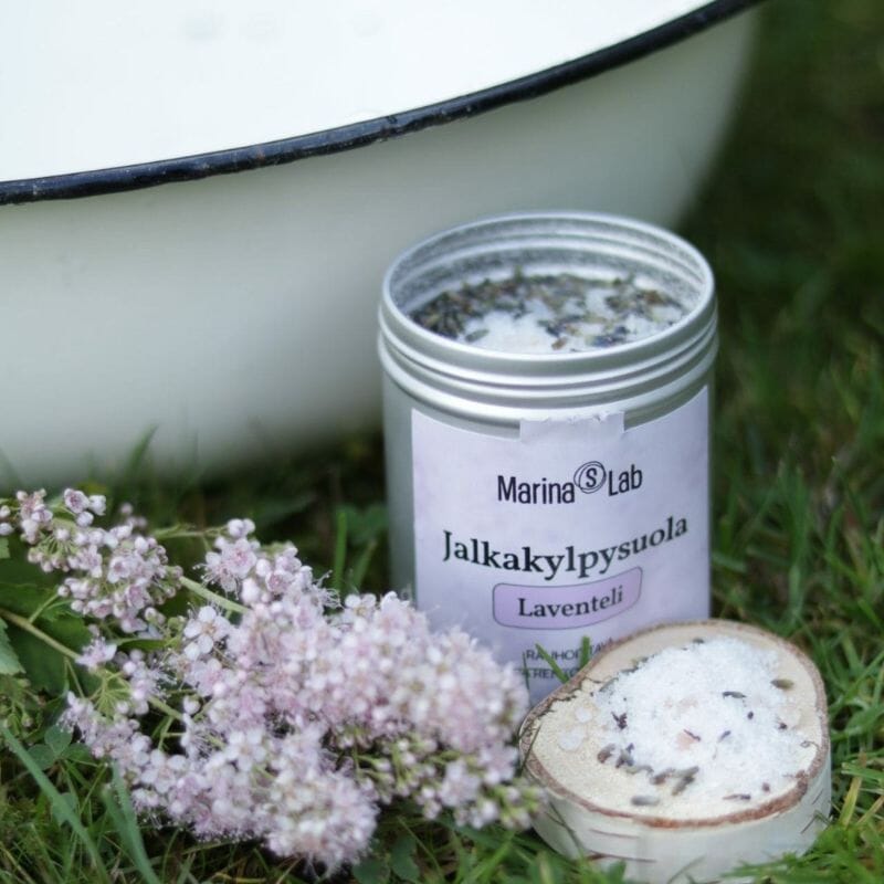 Marina's Labin Laventeli-jalkakylpysuola nurmikolle emalivadin viereen avatussa metallipurkissa.