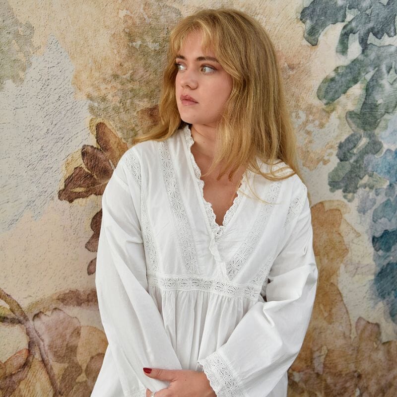 Tabitha-mallinen Powell Craftin naisten pitkähihainen puuvillainen yöpaita ruskea- ja petroolisävyiden seinän edessä seisovan naisen yllä.