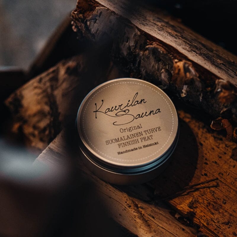 Kaurilan Saunan Tontun Saunasetti Ⅱ - Lahjapakettiin kuuluva Suomalainen turve tunnelmallisesti valaistussa halkokorissa.