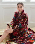 Powell Craft Velvet burgundy floral naisten puuvillainen kimono-aamutakki lampaantaljalla istuvan naisen yllä. 