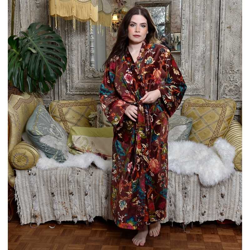 Powell Craft Velvet burgundy floral naisten puuvillainen kimono-aamutakki antiikkisen sohvan edessä seisovan tummahiuksisen naisen yllä. 