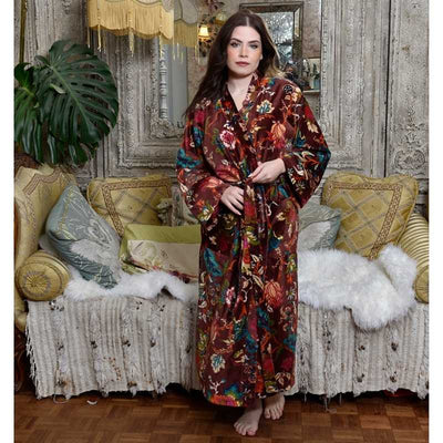 Powell Craft Velvet burgundy floral naisten puuvillainen kimono-aamutakki antiikkisen sohvan edessä seisovan tummahiuksisen naisen yllä. 