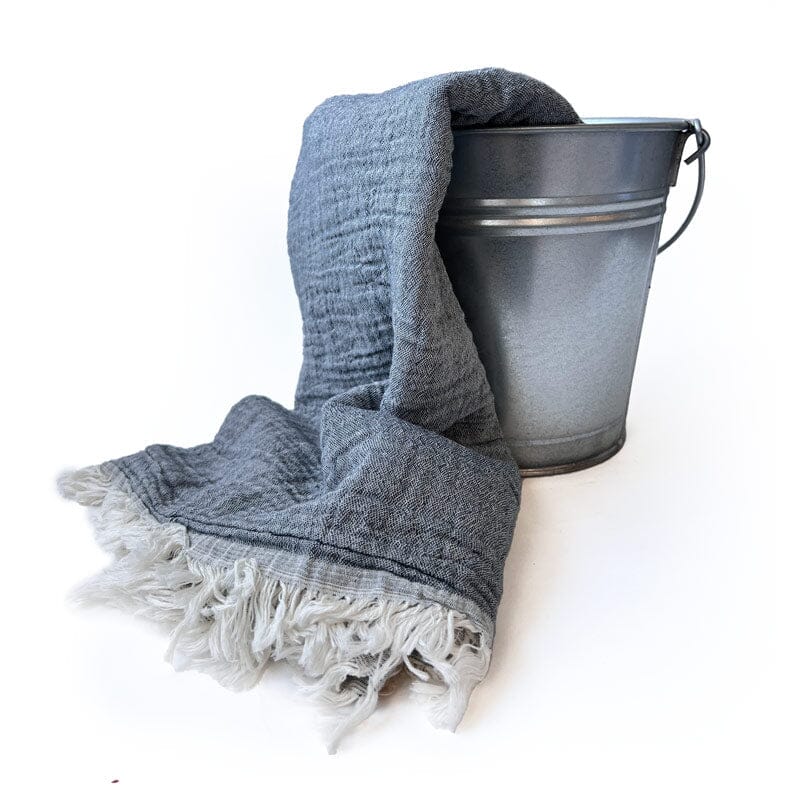 Saunatonttu by Kaurilan saunan Helenan Hamam-pyyhe sävyssä Kaarna, jossa pehmeästi ryppyinen harmaa pinta ja päissä vaaleat kevyehköt hapsut.