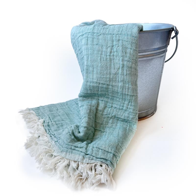 Saunatonttu by Kaurilan saunan Helenan Hamam-pyyhe sävyssä Minttu, jossa pehmeästi ryppyinen mintunvihreä pinta ja päissä vaaleat kevyehköt hapsut.