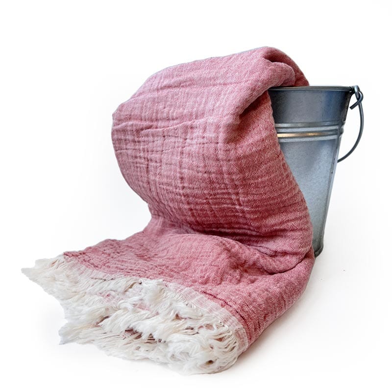Saunatonttu by Kaurilan saunan Helenan Hamam-pyyhe sävyssä Puolukka, jossa pehmeästi ryppyinen puolukkamarjapuuron värinen pinta ja päissä vaaleat kevyehköt hapsut.