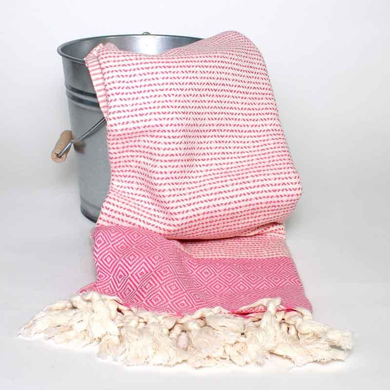 Saunatonttu by Kaurilan Saunan Jonnan Hamam-pyyhe sävyssä Pinkki, jossa valkoisella pohjalla reilusti pinkkejä salmiakki- ja raitakuvioita, sekä päädyissä muhkeat hapsut.