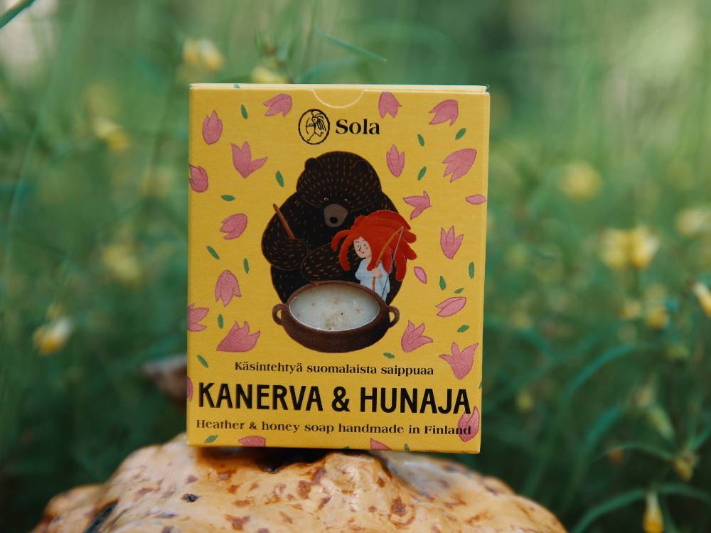 Solan Kanerva &amp; Hunaja -saippua pahkan päällä niityn reunalla.