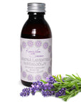 Kaurilan saunan 150ml Lempeä laventeli -vartaloöljy kierrekorkillisessa muovipullossa, jossa on valkoinen, lilakoristeinen etiketti. Edessä laventelinoksia.