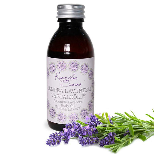 Kaurilan saunan 150ml Lempeä laventeli -vartaloöljy kierrekorkillisessa muovipullossa, jossa on valkoinen, lilakoristeinen etiketti. Edessä laventelinoksia.