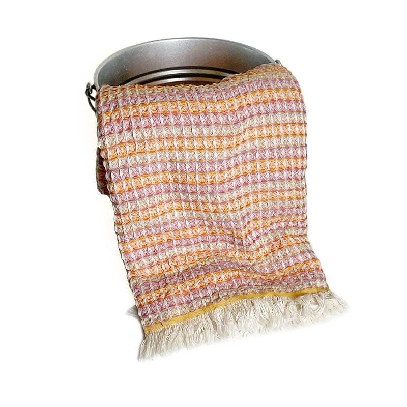 Saunatonttu by Kaurilan saunan Liisin Hamam-vohvelipyyhe sävyssä Oranssi-vaaleanpunainen, jossa päissä vaaleat kevyet hapsut.