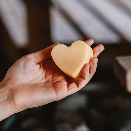 Sydämenmuotoinen palashampoo ihmisen kämmenellä.