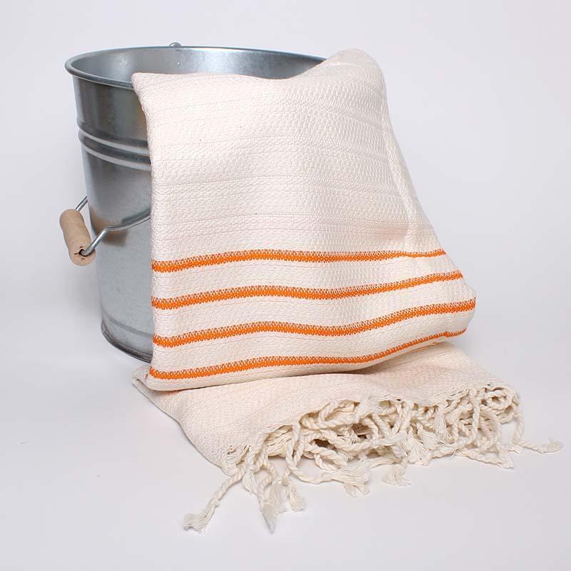 Saunatonttu by Kaurilan Saunan Ullan Hamam-pyyhe jossa valkoisella pohjalla oransseja raitoja, sekä kierrehapsut.
